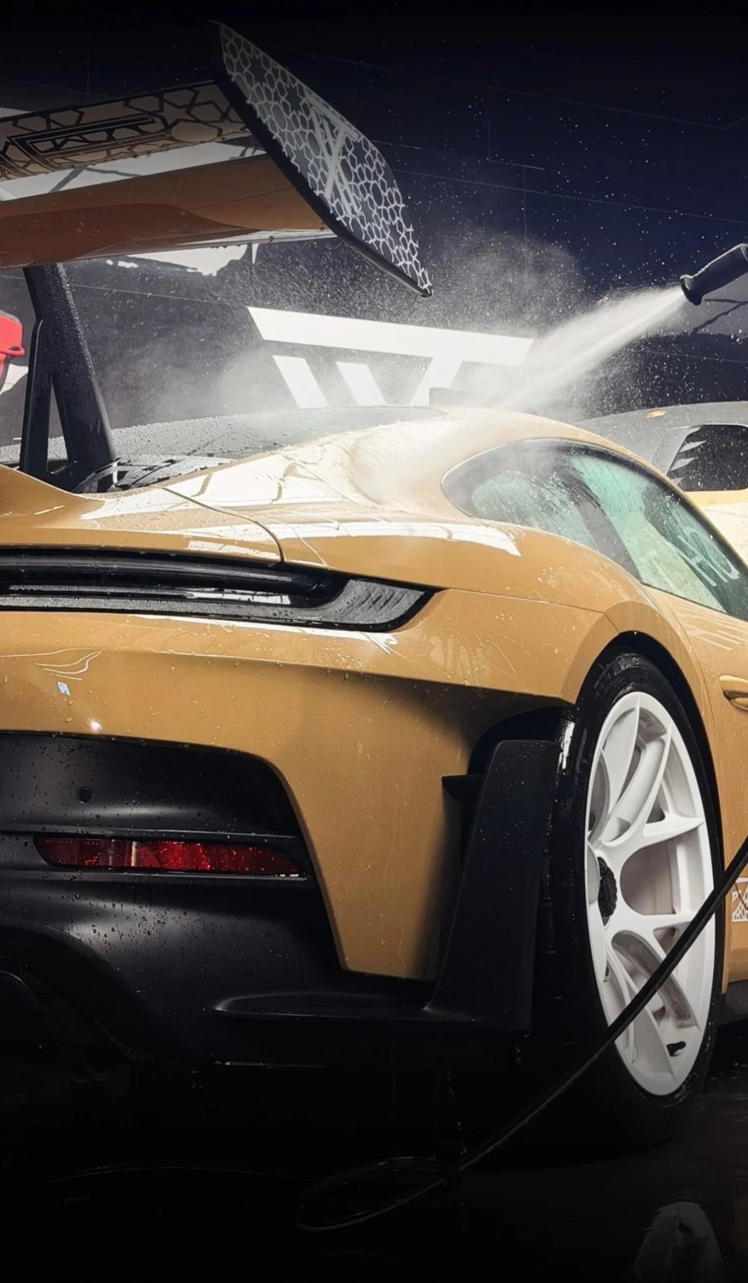Gold Porsche rear spoiler and bodywork in an installation studio